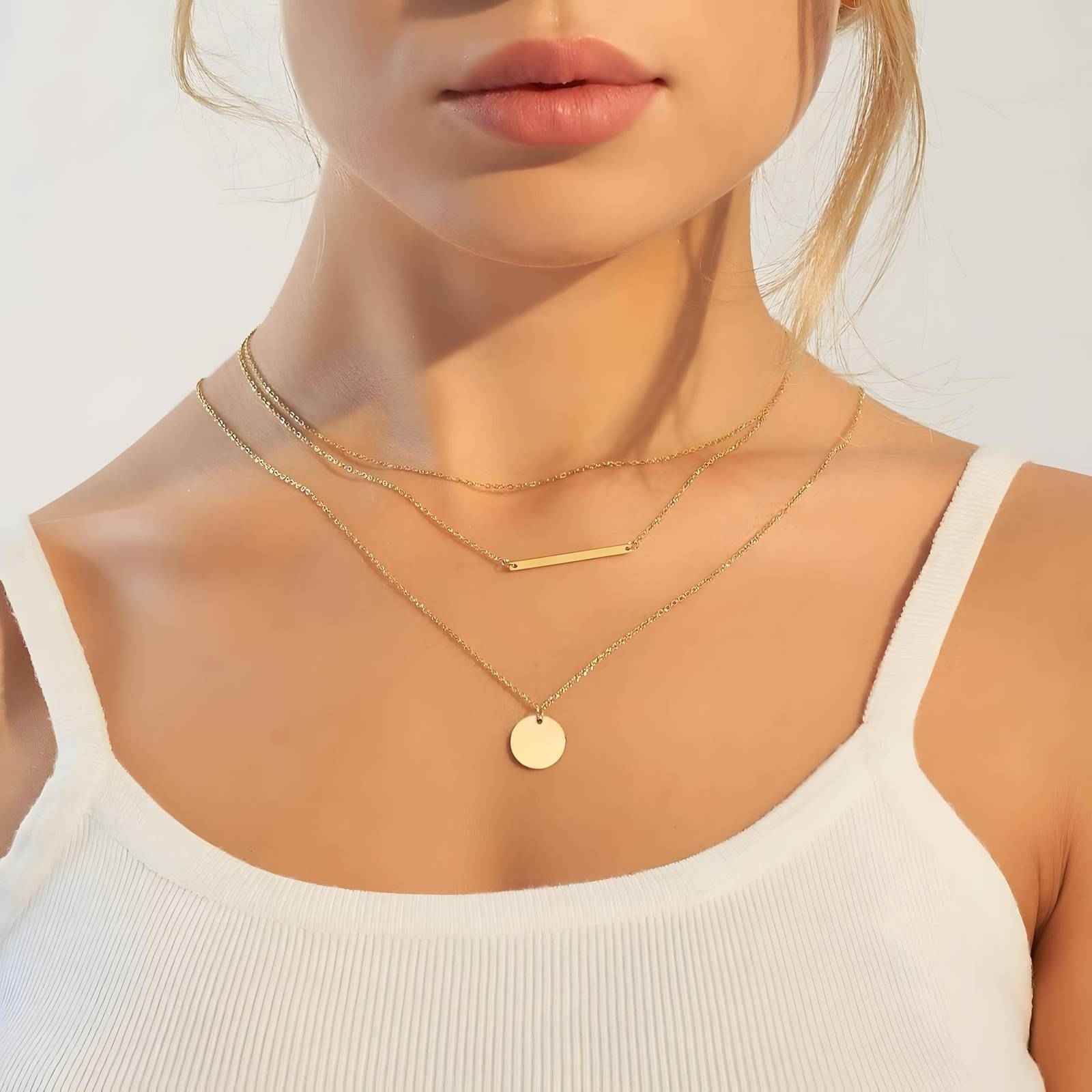 18K Gold Plated Steel Necklace layered on model, featuring minimalist bar and round pendant. Waterproof and hypoallergenic jewelry for everyday wear.